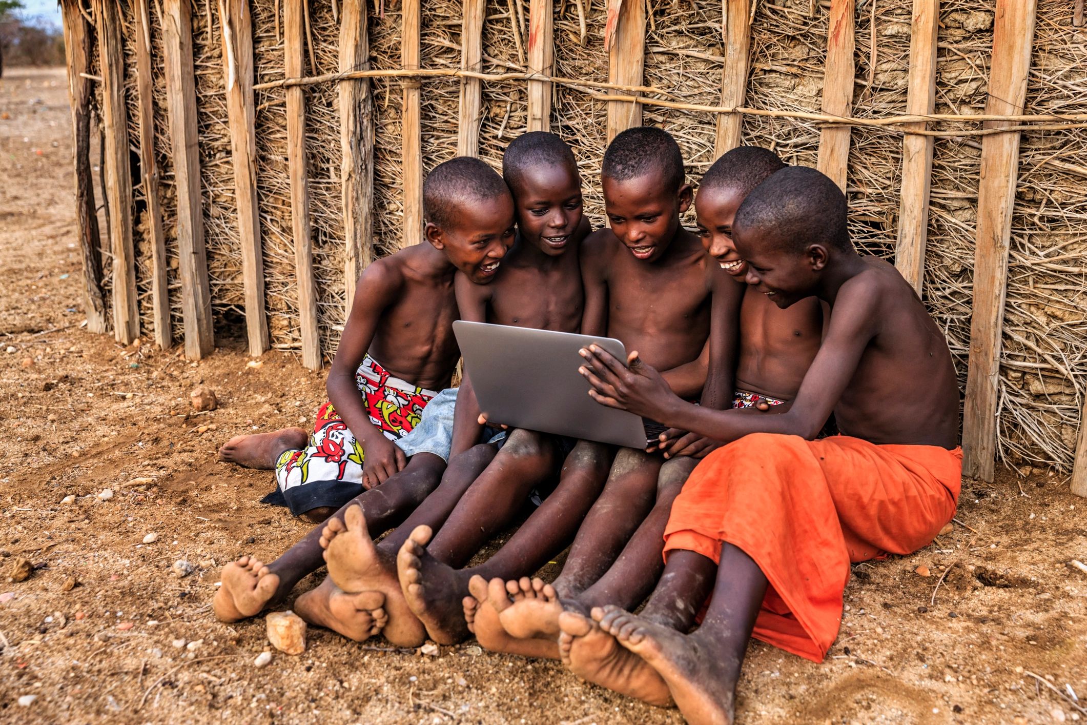 Group of children learning together in a village setting