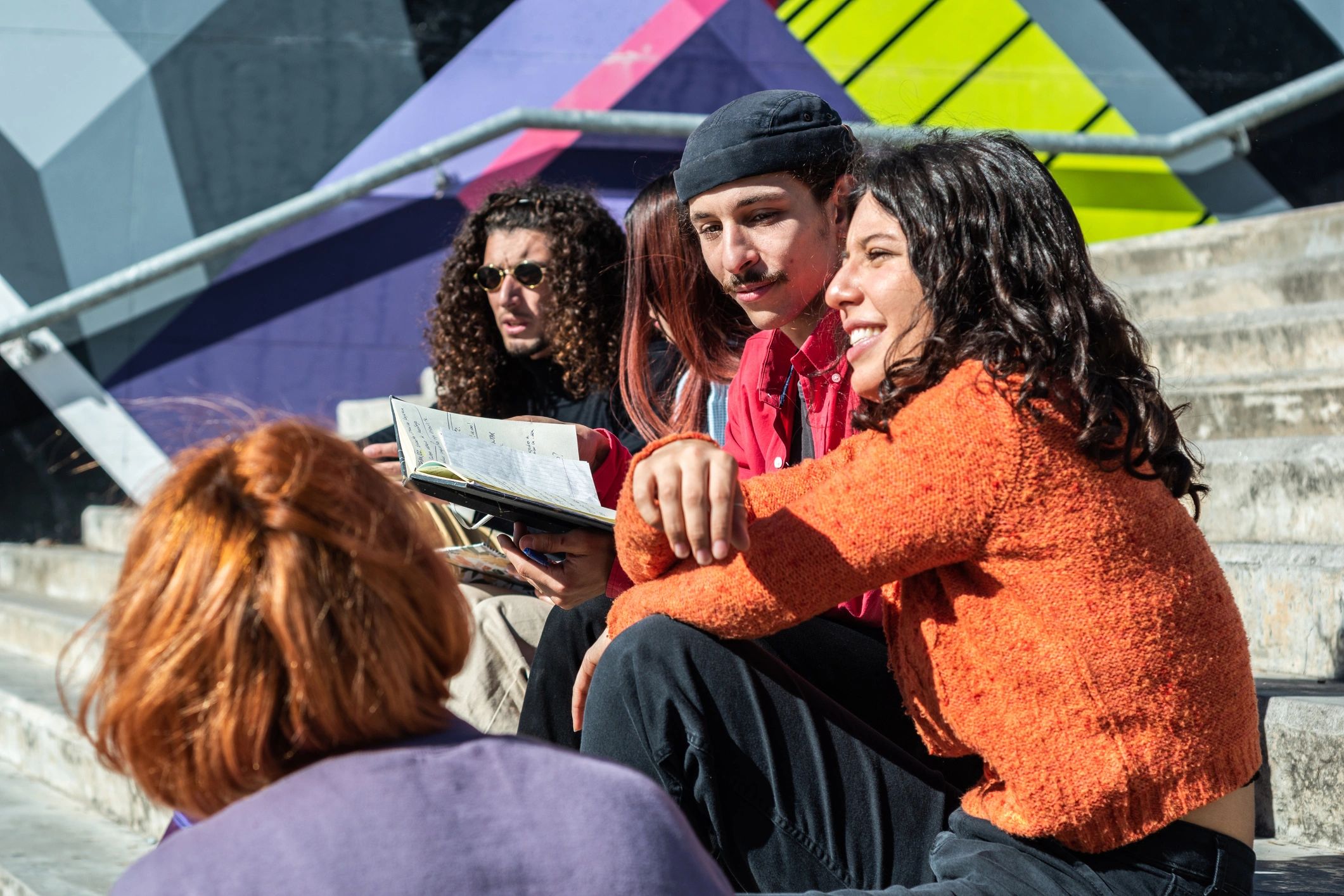Group of young people talking and studying together on steps