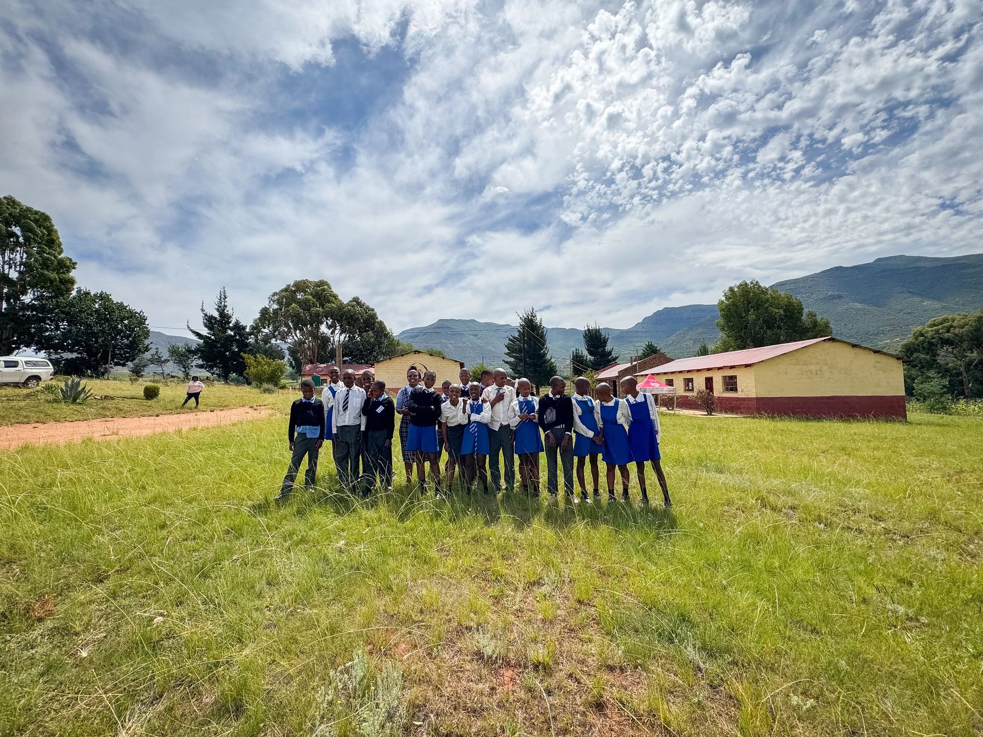 Group of African school children in uniform outside a rural school