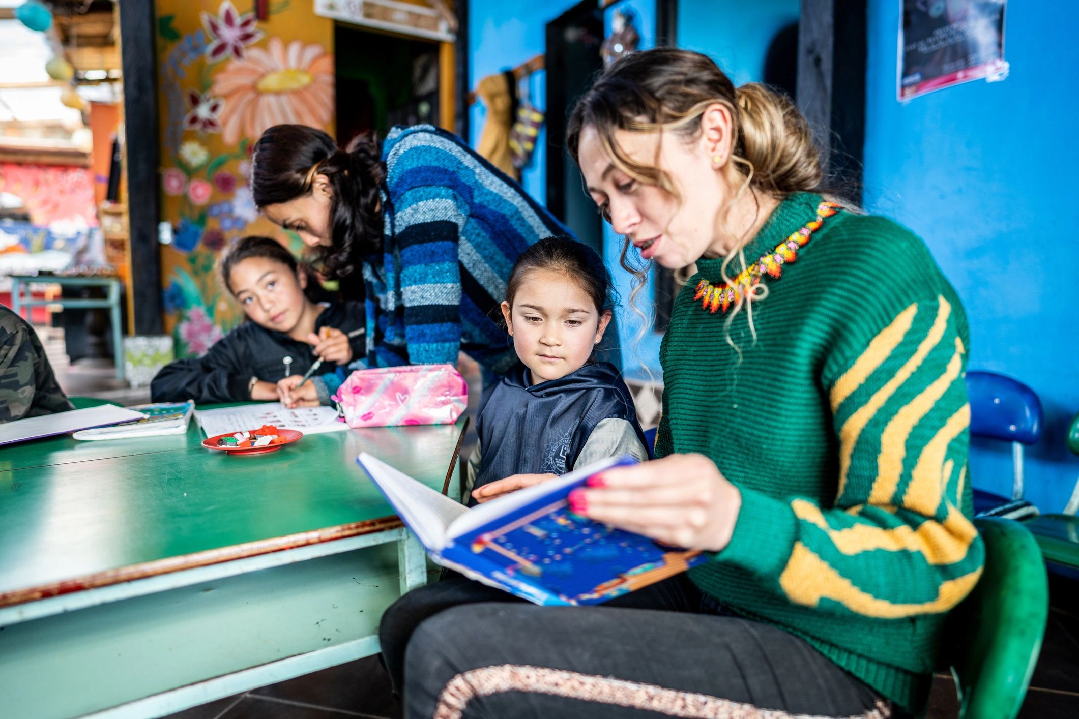 Teacher reading with a student in a classroom setting
