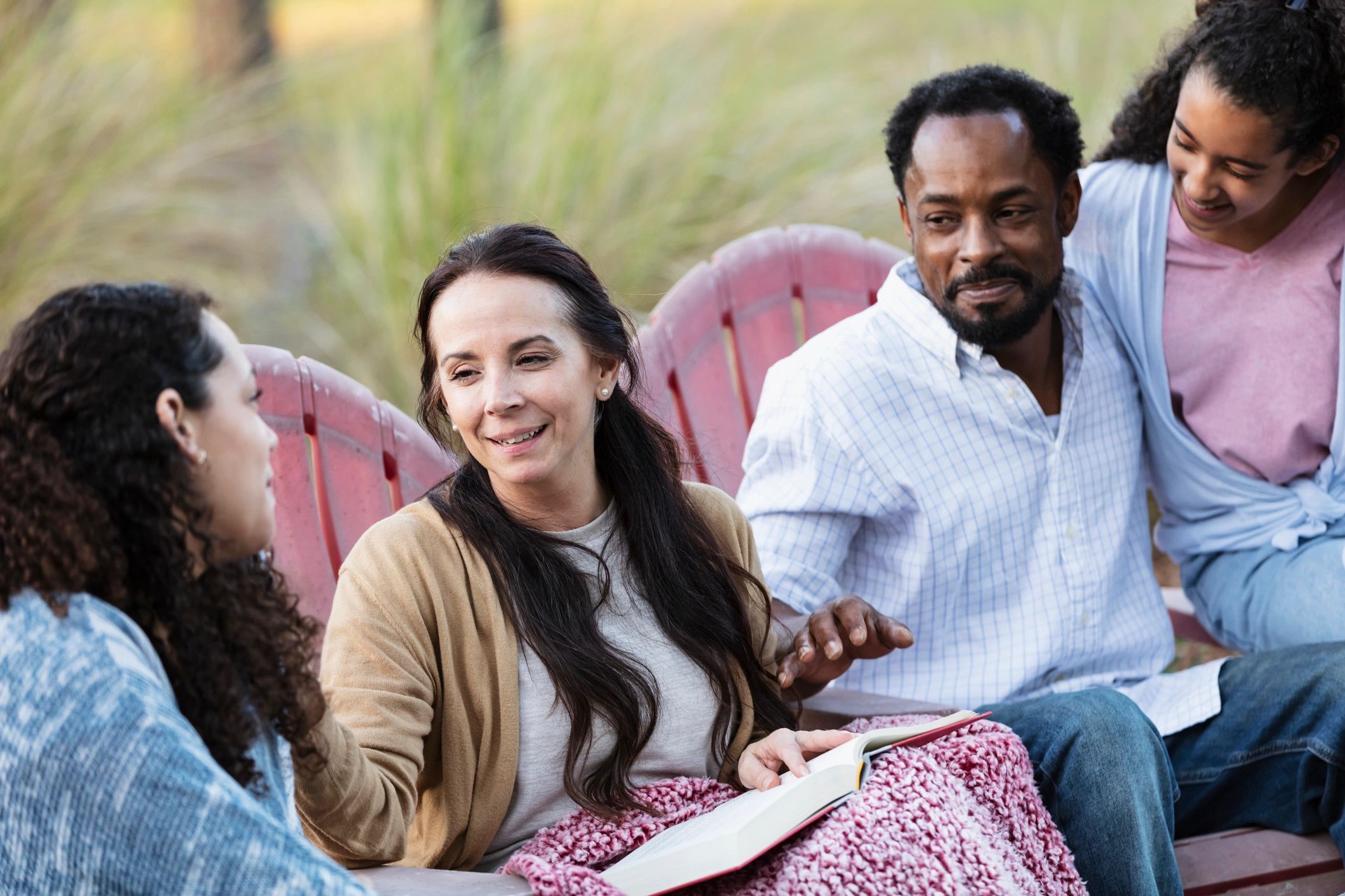 Family and young people sitting together outdoors in conversation