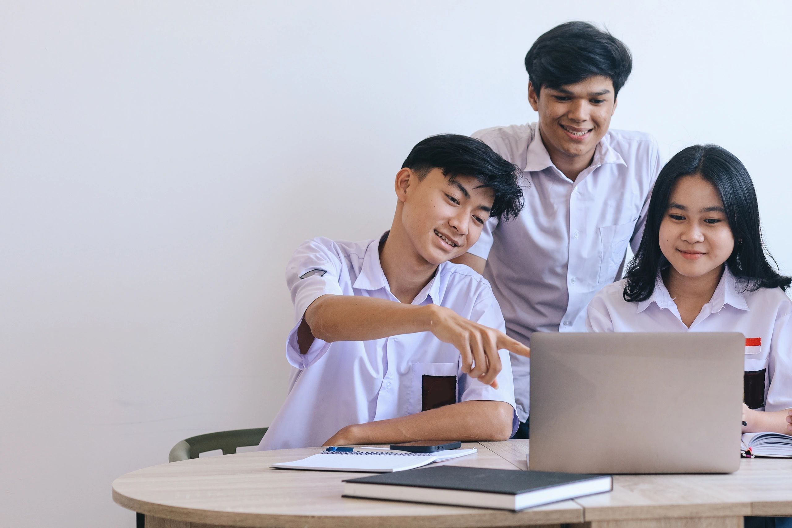 Students collaborating on a laptop for a school assignment