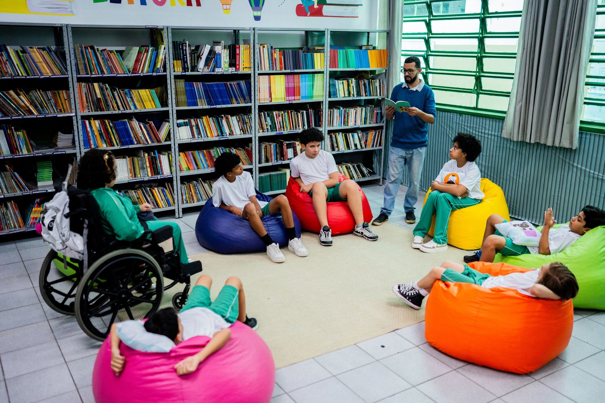 Teacher reading aloud to children in a school library