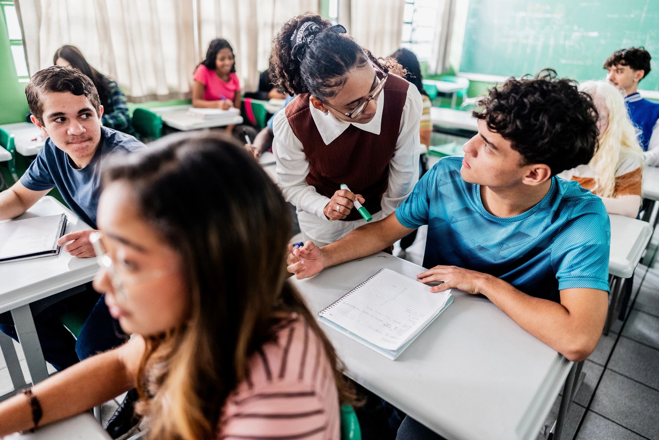 Teacher assisting a teenager during class